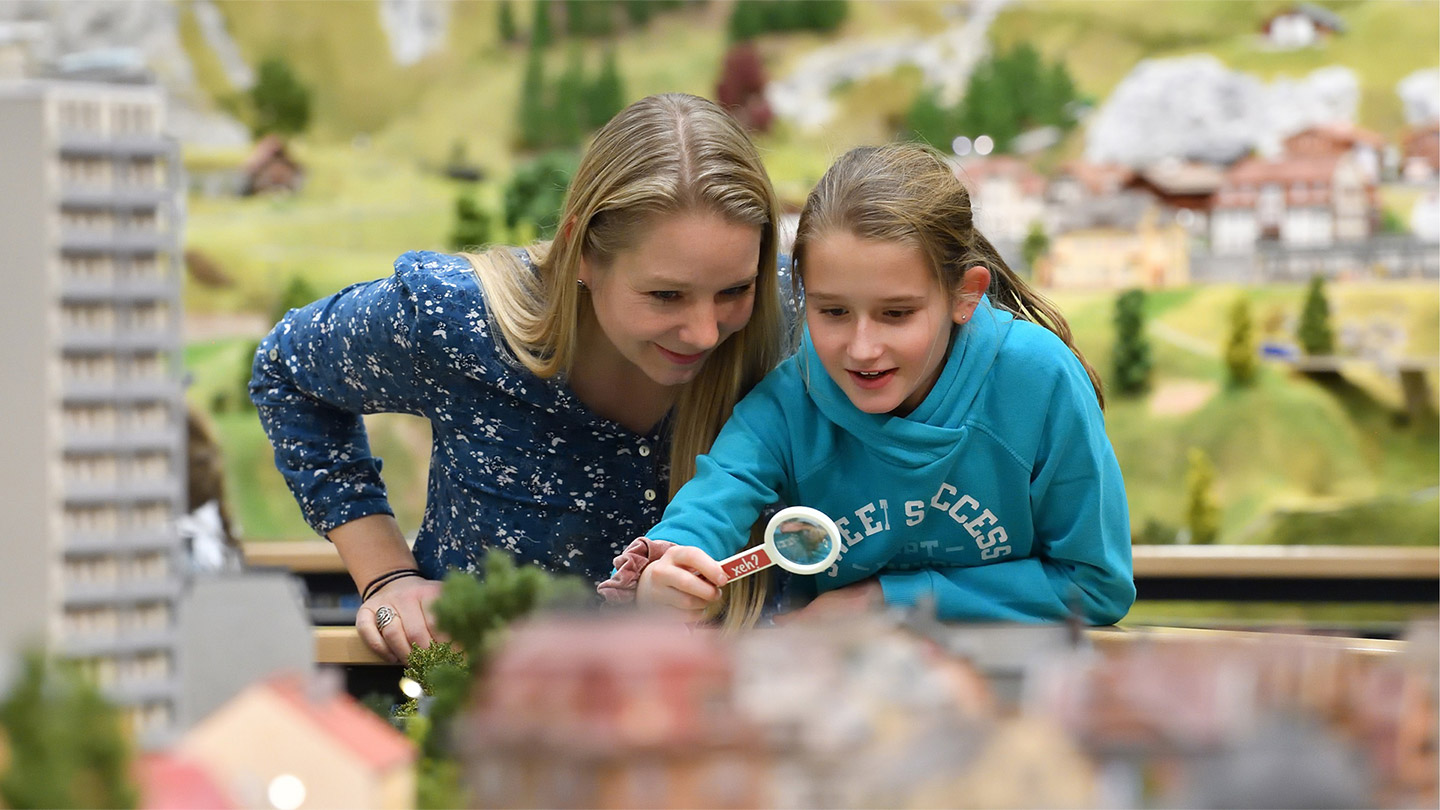 Zwei Mädchen schauen ein Detail mit der Lupe an